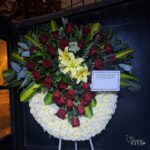 Corona fúnebre de pompones blancos con rosas rojas y liliums con parante – Siempre Viva Florería en Jesús María y Pueblo Libre